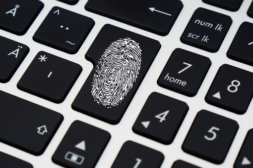 Impronta digitale su tastiera PC a rappresentare un'identità digitale