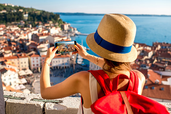 Giovane turista con zaino rosso e macchina fotografica godendo la vista sulla corsa di pirano vecchia bicicletta in slovenia